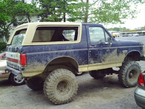 1990 Ford Bronco - This lifted 1990 Ford Bronco features a two-tone paint scheme with a tan removable top.