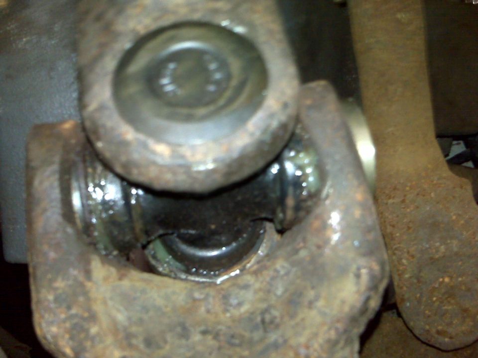 Close-up of a heavily rusted universal joint with grease visible