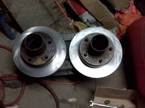1995 Ford Bronco - Pair of brake rotors, likely for a truck or SUV, resting on a surface with tools nearby.