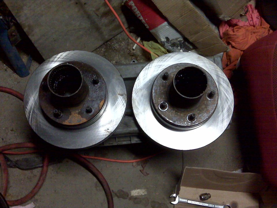 Two brake rotors with hubs, one showing rust