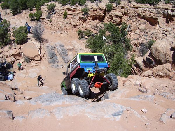 1991 Ford Bronco climbing rocky terrain, multiple people watching