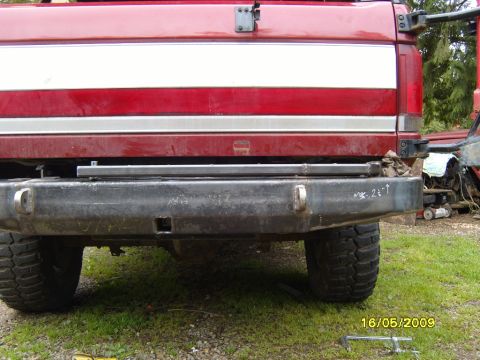 1989 Ford Bronco - Rear view of a red truck with an aftermarket bumper and visible tires.