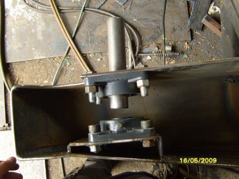 1989 Ford Bronco - Close-up of a metal bracket assembly with bearings and bolts, likely a component part.