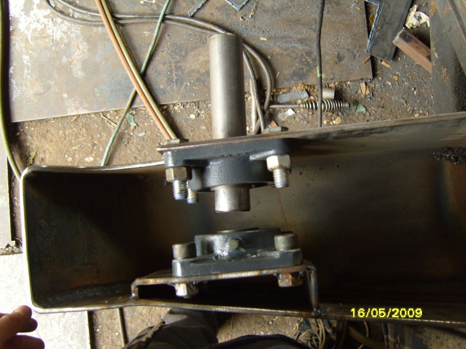 Metal bracket with bearings and bolts, viewed from the front