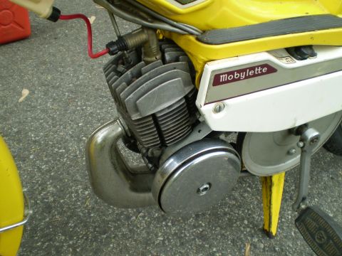 1981 Garelli Rally Sport - The engine and side panel of a yellow Motobecane Mobylette moped are shown in detail.