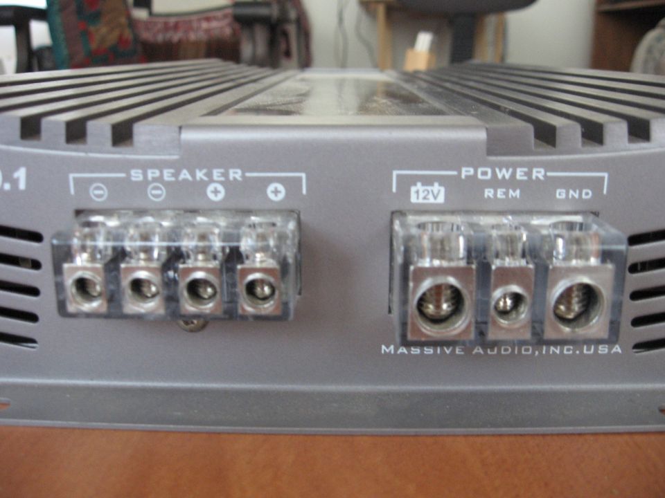 Car amplifier with speaker and power terminals, labeled "MASSIVE AUDIO, INC. USA"