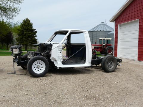 1994 Ford F-150 - Truck chassis undergoing restoration, with a tractor and barn in the background.