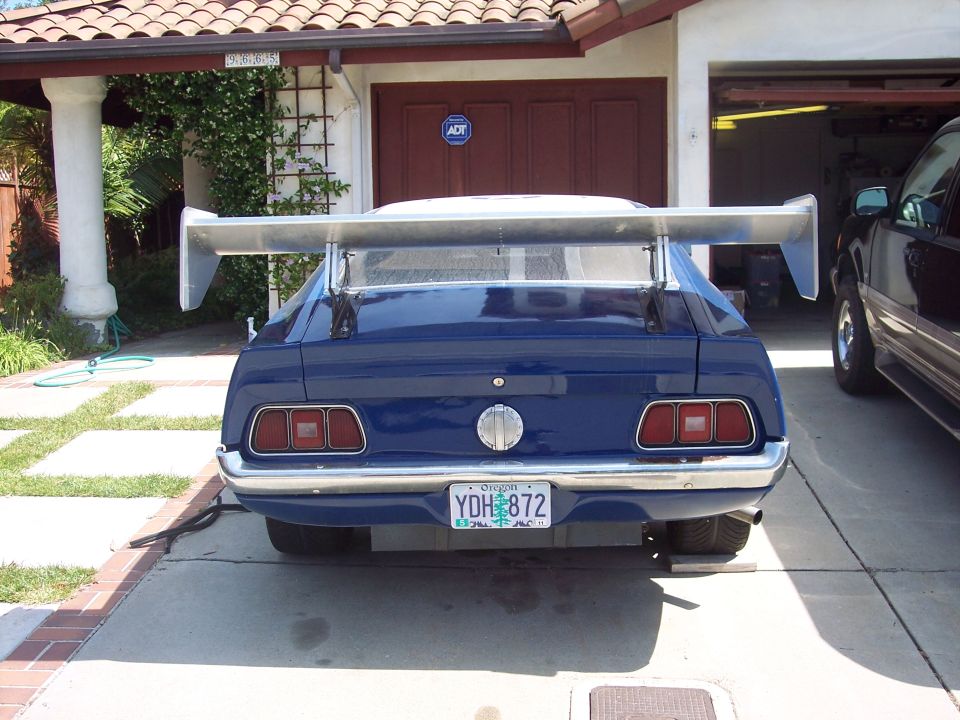 Blue 1971 Ford Mustang rear view with large spoiler and custom license plate
