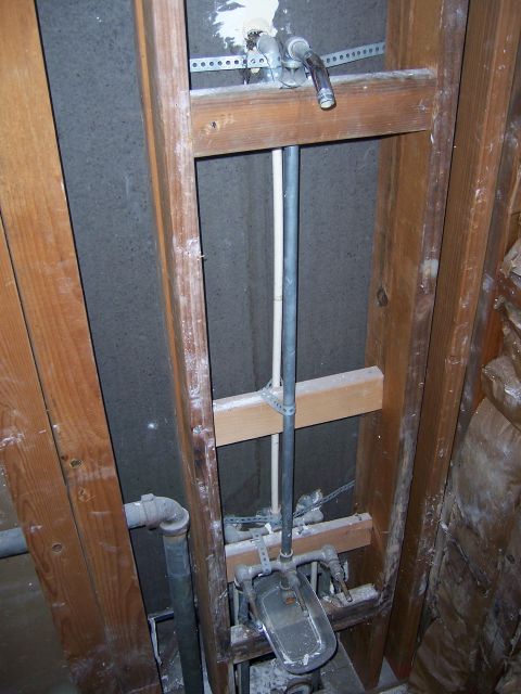 1991 Ford Bronco - Plumbing pipes and shower valve are visible behind wall framing, likely during construction or repair.