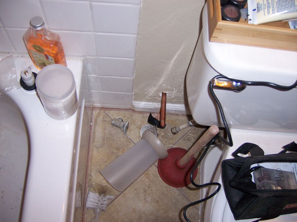 Toilet and bathtub with plunger, brush, and plumbing parts