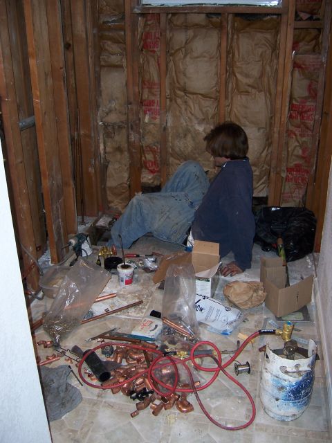 1991 Ford Bronco - A person sits amidst plumbing supplies during a bathroom renovation.