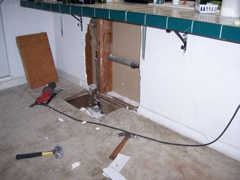 1991 Ford Bronco - A construction scene shows tools scattered on the floor around an opening in the wall revealing plumbing pipes.