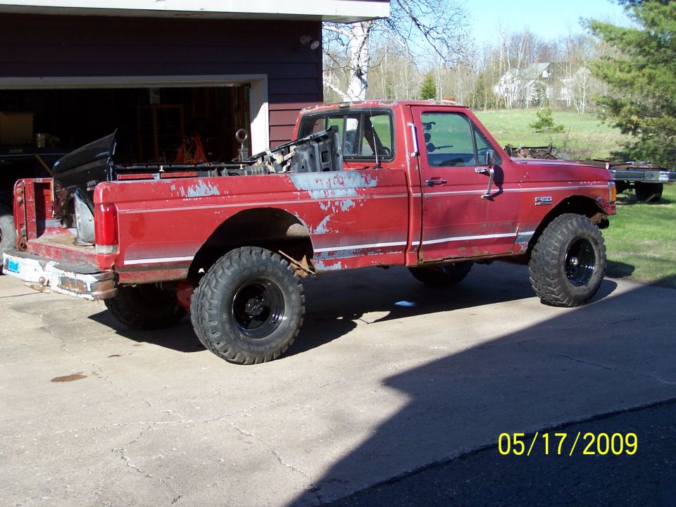 Red 1989 Ford F-150 pickup truck, lifted, with large tires