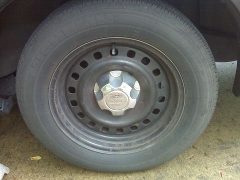 2001 Ford Crown Victoria - Close-up of a Ford wheel, likely from a Crown Victoria, showing the hubcap and tire.