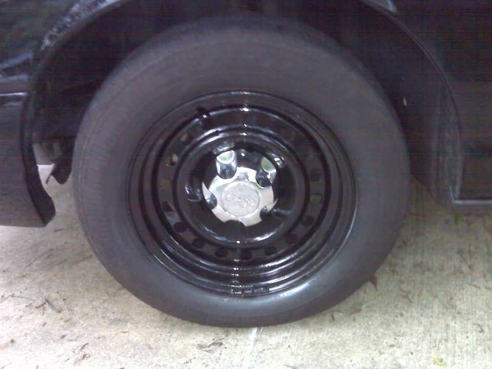 Black steel wheel with a chrome hubcap on a black vehicle