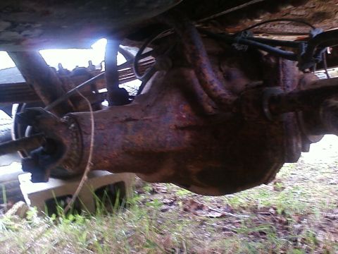 1990 Ford Bronco - Close-up of a heavily rusted rear axle assembly, likely from an older vehicle.