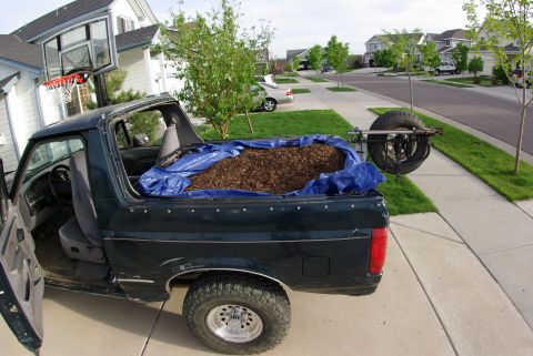 1995 Ford Bronco - 1995 Ford Bronco loaded with mulch, a spare tire mounted externally on the rear.