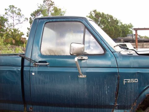 1985 Ford F-250 - A teal Ford F-250 truck is seen from the side, with a visible F250 badge on the fender.