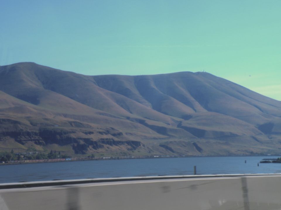 Mountainous landscape with a body of water and a clear blue sky