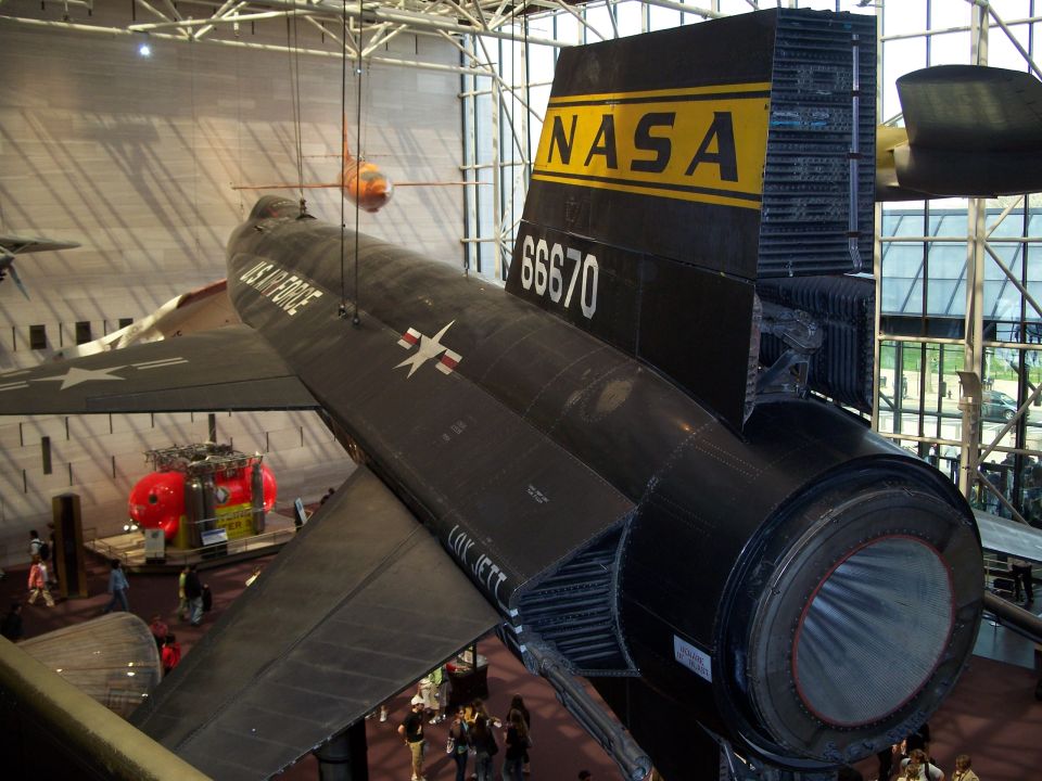 Black NASA aircraft with yellow tail markings and number 66670, viewed from the rear