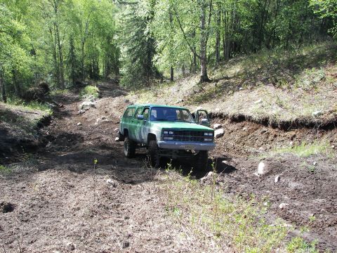 1990 Chevrolet Suburban - 1990 Chevrolet Suburban navigating a rough, dirt path through a forest.