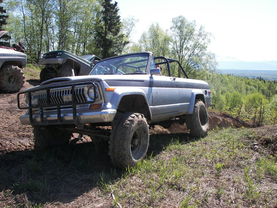 Light blue convertible SUV with off-road tires and brush guard on uneven terrain