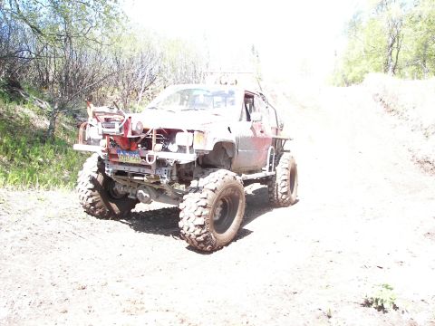 1990 Chevrolet Suburban - This heavily modified truck features oversized tires and a custom front bumper, suggesting it's built for off-road use.