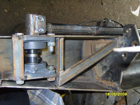 1989 Ford Bronco - Close-up view of a metal frame assembly with a bearing, bolts, and welded joints.