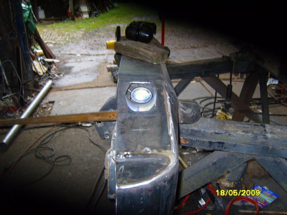 Custom fabricated steel rear bumper section with a circular cutout for a light. Shows welding and metalwork