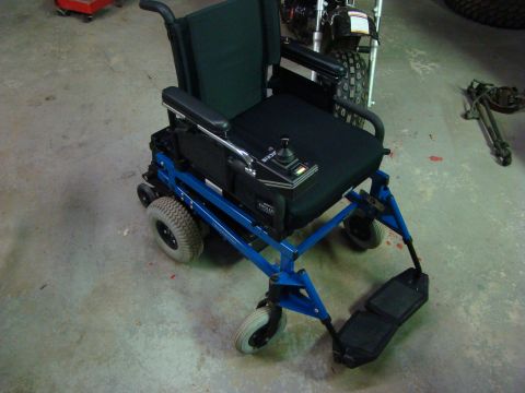 1948 Jeep Wrangler - An electric wheelchair with a blue frame and black seat is shown in a garage setting.