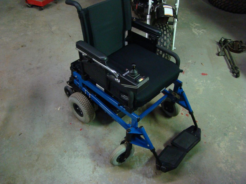 Blue electric wheelchair with joystick control and black seat