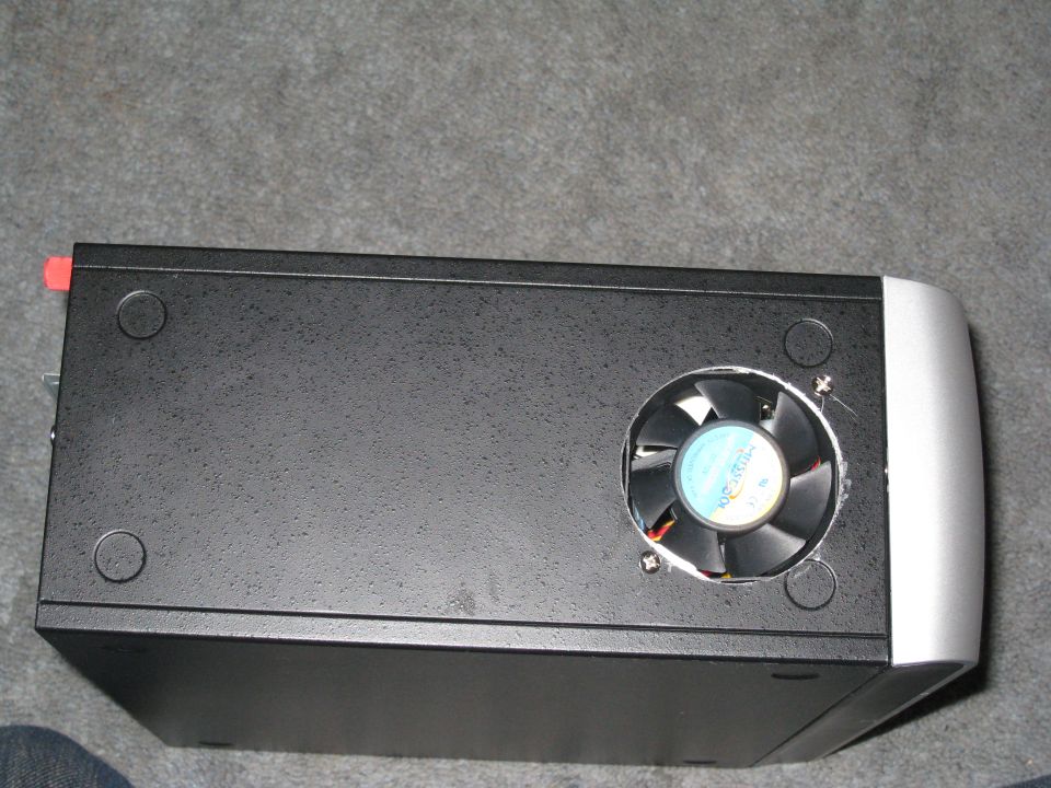 Black computer case with a fan on top and silver trim on the right side