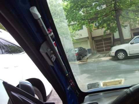 2007 Subaru Impreza - Custom car accessories are mounted on the windshield pillar, with a street scene and parked vehicles visible through the window.