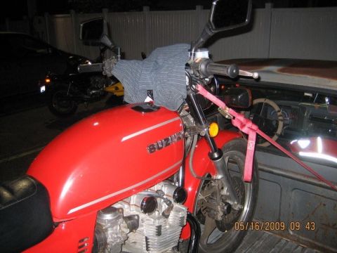 1985 Ford LTD Crown Victoria - A red Suzuki motorcycle is secured in a truck bed, with another motorcycle in the background.