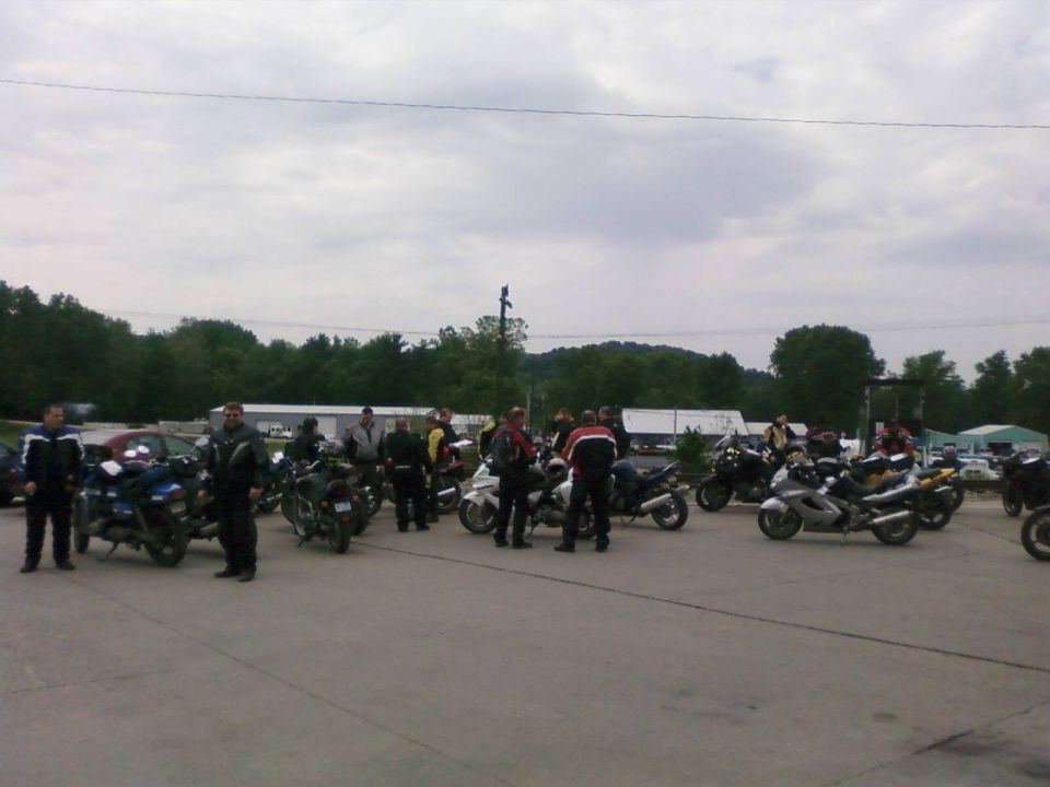 Group of motorcycles and riders gathered in a parking lot
