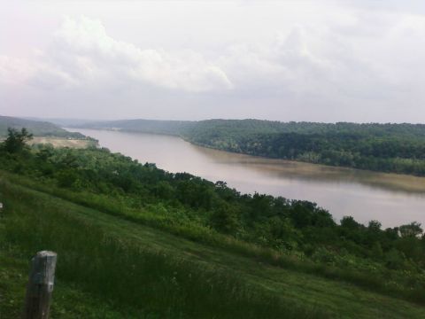 1985 Ford LTD Crown Victoria - A scenic view of a wide river winding through a lush, green valley on an overcast day.