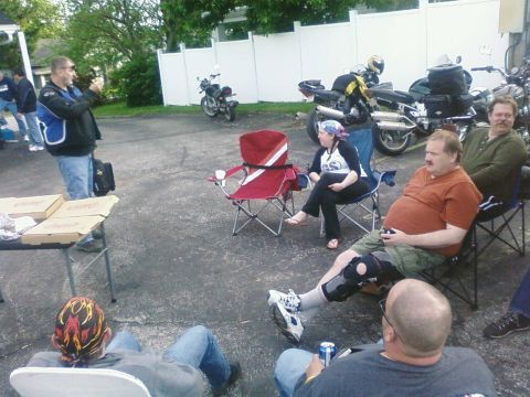 1985 Ford LTD Crown Victoria - A group of people are gathered around parked motorcycles in an outdoor setting.