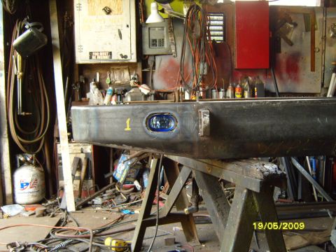 1989 Ford Bronco - A custom-fabricated rear bumper, possibly for an off-road vehicle, is shown in a cluttered garage setting.