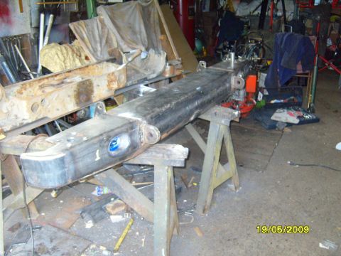 1989 Ford Bronco - A heavy-duty frame section, possibly from a truck or SUV, is supported by sawhorses in a workshop setting.