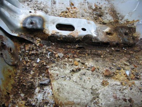 2003 Ford Crown Victoria - Extensive rust and debris cover the floor pan of a vehicle, with the SuperMotors logo visible in the corner.