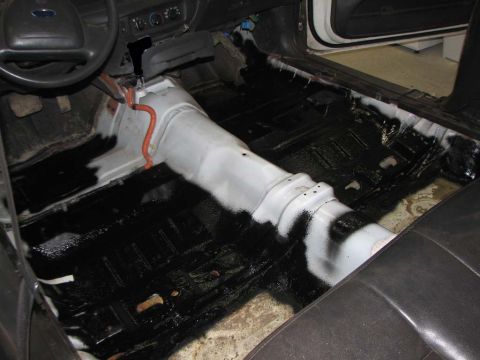 2003 Ford Crown Victoria - The interior floor of a vehicle has been stripped down and treated with sound deadening material.