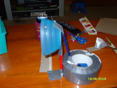 1989 Ford Bronco - A collection of household items including duct tape, scissors, a remote, and a soda can are arranged on a wooden table.
