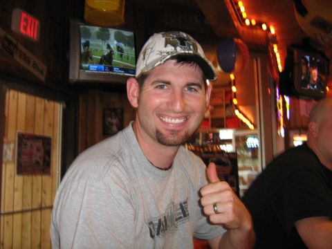 1993 Ford Bronco - A man smiles and gives a thumbs up while sitting in a bar with multiple televisions visible.