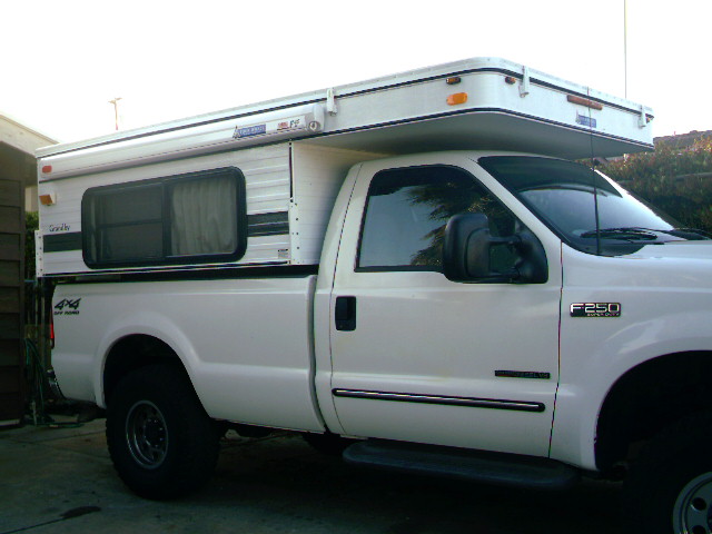 White 2000 Ford F-250 with camper shell, side view