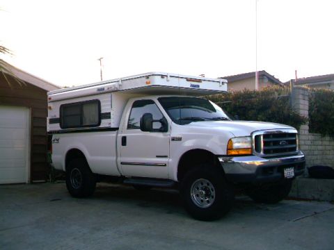2000 Ford F-250 - This pickup truck is equipped with a camper shell, extending its utility for travel and outdoor activities.