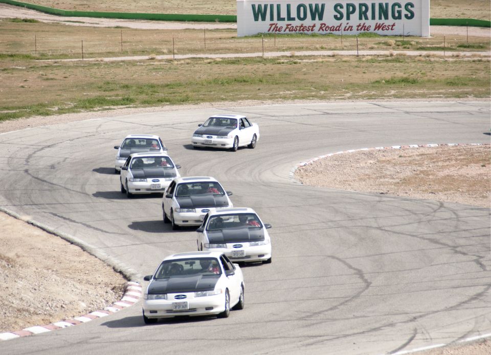 White Ford Taurus sedans with black hoods on a race track