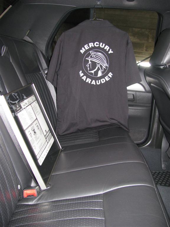 Black t-shirt with Mercury Marauder logo hanging on car seat. Window sticker on seat