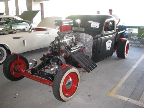 2003 Mercury Marauder - A custom hot rod with a prominent supercharger and red wheels is displayed next to a white convertible.