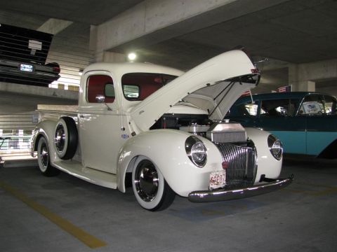 2003 Mercury Marauder - A classic white pickup truck is displayed with its hood open, revealing the engine bay, parked indoors.