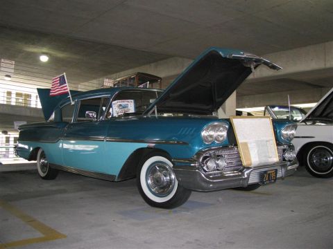 2003 Mercury Marauder - A classic two-tone blue sedan is displayed with its hood and trunk open, an American flag attached to the fender.